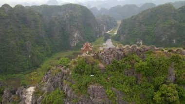 Küçük tapınağın ve Kuzey Vietnam 'da turistik bir yer olan Ninh Binh' deki Mua Mağarası dağının tepesindeki ejderhanın hava görüntüsü. Vietnam 'a seyahat.
