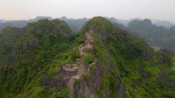 Luchtfoto van de kleine tempel en een draak op de top van marmeren berg, Mua Cave berg, in Ninh Binh, een toeristische bestemming in het noorden van Vietnam. Reis naar Vietnam concept. — Stockvideo