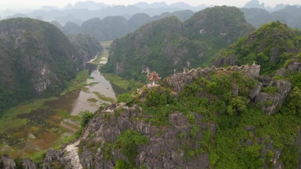 Luchtfoto van de kleine tempel en een draak op de top van marmeren berg, Mua Cave berg, in Ninh Binh, een toeristische bestemming in het noorden van Vietnam. Reis naar Vietnam concept. — Stockvideo