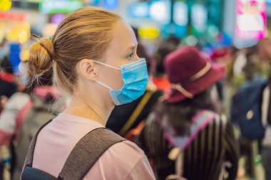 Havaalanındaki koronavirüsü korumak için tıbbi maskeli kadın gezgin.
