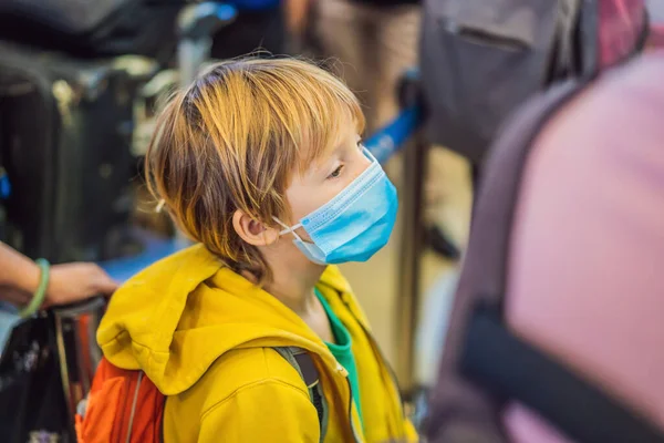 공항에서 코로나 바이러스를 보호하기 위해 의료 마스크를 착용하고 여행하는 소년 — 스톡 사진