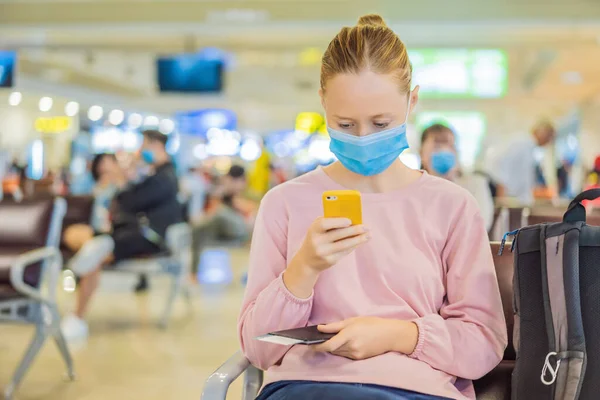 Женщина-путешественница в медицинской маске для защиты коронавируса в аэропорту — стоковое фото