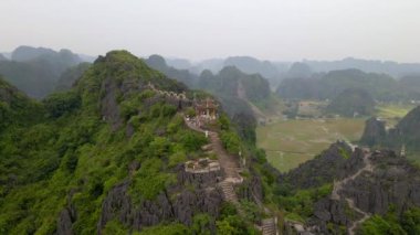 Küçük tapınağın ve Kuzey Vietnam 'da turistik bir yer olan Ninh Binh' deki Mua Mağarası dağının tepesindeki ejderhanın hava görüntüsü. Vietnam 'a seyahat.