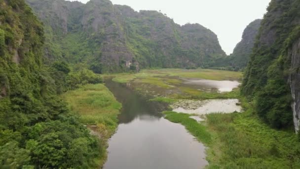 Аэросъемка красивых известняковых гор с перевалами, вырезанными рекой в регионе Нинь Бинь, известном туристическом курорте на севере Вьетнама. Концепция путешествия во Вьетнам — стоковое видео