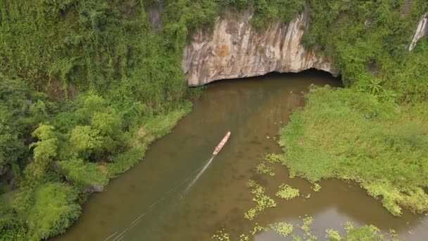 Colpo aereo di belle montagne calcaree con passi scolpiti da un fiume nella regione di Ninh Binh, una famosa destinazione turistica nel nord del Vietnam. Viaggio in Vietnam concetto. Un ingresso ad una grotta che — Video Stock
