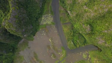 Kuzey Vietnam 'da ünlü bir turizm merkezi olan Ninh Binh bölgesinde nehir tarafından oyulmuş güzel kireçtaşı dağlarının hava görüntüleri. Vietnam 'a seyahat