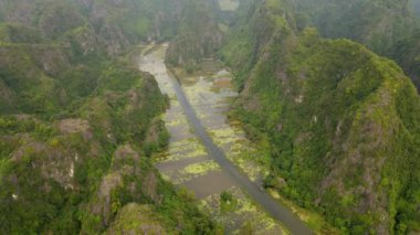 Kuzey Vietnam 'da ünlü bir turizm merkezi olan Ninh Binh bölgesinde nehir tarafından oyulmuş güzel kireçtaşı dağlarının hava görüntüleri. Vietnam 'a seyahat