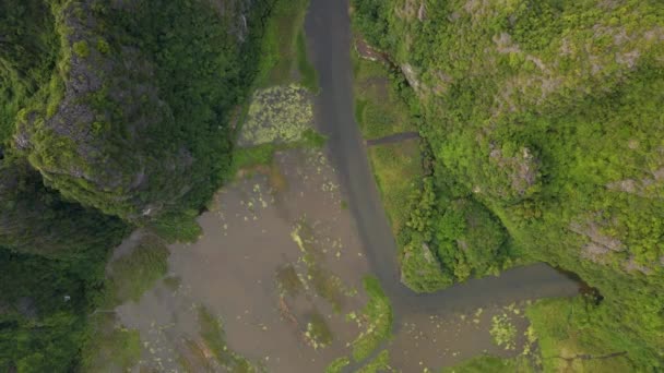 Luftaufnahme wunderschöner Kalksteinberge mit Pässen, die von einem Fluss in der Region Ninh Binh, einem berühmten Touristenziel im Norden Vietnams, geschnitzt wurden. Reise nach Vietnam — Stockvideo