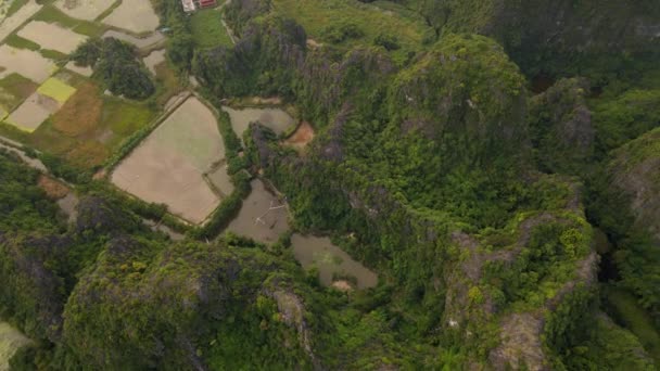 Flygfoto av vackra kalksten berg med passerar ristade av en flod i Ninh Binh regionen, en berömd turistmål i norra Vietnam. Resor till Vietnam konceptet — Stockvideo