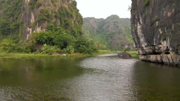 Foto aérea de hermosas montañas de piedra caliza con pasos tallados por un río en la región de Ninh Binh, un famoso destino turístico en el norte de Vietnam. Viajar a Vietnam concepto — Vídeo de stock