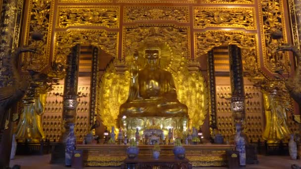 Una toma de mano de la estatua de Buda sentada dorada en la pagoda Bai Dinh en el complejo de templos más grande de Ninh Binh Vietnams. Viajar a Vietnam concepto — Vídeo de stock