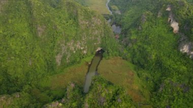 Kuzey Vietnam 'da ünlü bir turizm merkezi olan Ninh Binh bölgesinde nehir tarafından oyulmuş güzel kireçtaşı dağlarının hava görüntüleri. Vietnam 'a seyahat