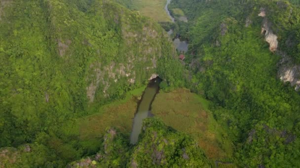 Flygfoto av vackra kalksten berg med passerar ristade av en flod i Ninh Binh regionen, en berömd turistmål i norra Vietnam. Resor till Vietnam konceptet — Stockvideo