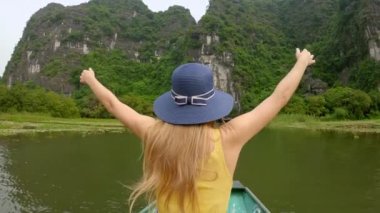 Kuzey Vietnam 'da turistik bir yer olan Ninh Binh' de muhteşem kireçtaşı kayaları arasında nehir gezisi yapan genç bir kadın. Vietnam 'a seyahat