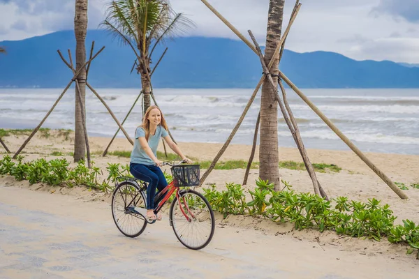 Mujer joven con bicicleta disfrutando de un paseo en bicicleta por el mar — Foto de Stock