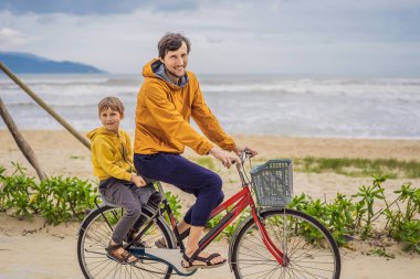 Baba ve oğlu, güzel bir manzarada, bir yaz gününde bisikletle hafta sonu gezintisine çıkıyorlar.