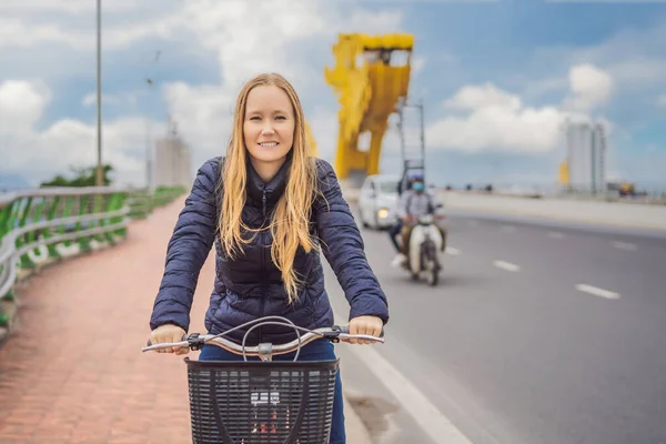 Da Nang 'da ejderha köprüsünde bisiklet süren bir kadın. — Stok fotoğraf