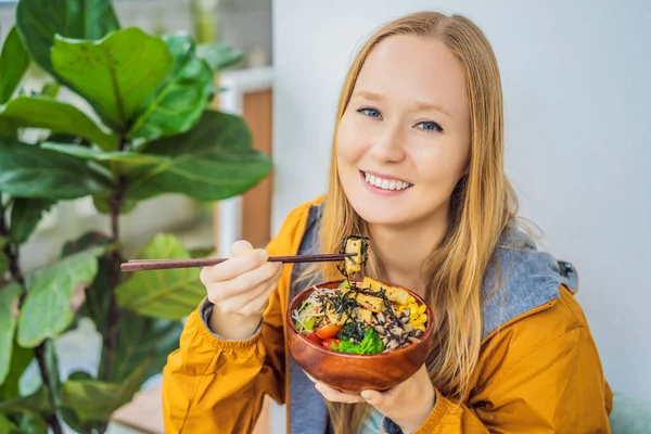 Женщина ест сырую органическую миску с рисом и овощами крупным планом на столе. Вид сверху горизонтальный — стоковое фото