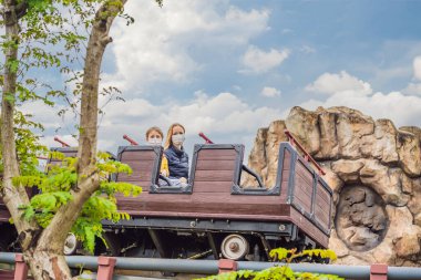 Anne ve oğlu COVID-19 Coronavirüs sırasında hız treninde tıbbi maske takıyor.