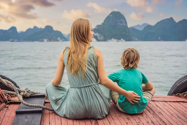 Mom and son travelers is traveling by boat in Halong Bay. Vietnam. Travel to Asia, happiness emotion, summer holiday concept. Traveling with children concept. After COVID 19. Picturesque sea landscape