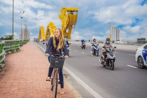 女はダナンの龍橋で自転車に乗る — ストック写真