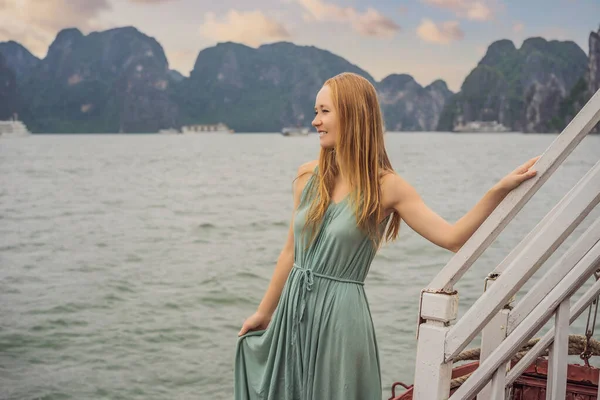 Attractive woman in a dress is traveling by boat in Halong Bay. Vietnam. Travel to Asia, happiness emotion, summer holiday concept. Picturesque sea landscape. Ha Long Bay, Vietnam — Stock Photo, Image