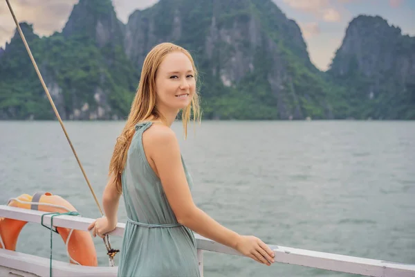 Ελκυστική γυναίκα σε ένα φόρεμα ταξιδεύει με βάρκα στο Halong Bay. Βιετνάμ. Ταξίδι στην Ασία, συναίσθημα ευτυχίας, καλοκαιρινές διακοπές έννοια. Γραφικό θαλάσσιο τοπίο. Ha Long Bay, Βιετνάμ — Φωτογραφία Αρχείου