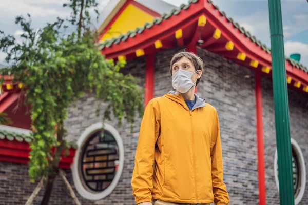 戴着医疗面罩的游客在街上停下脚步，看着日本、中国、韩国、越南的传统建筑。验尸官流行病爆发后，游客们在亚洲旅行 — 图库照片
