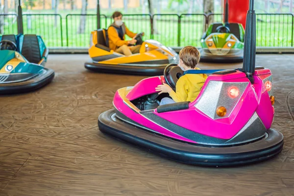 Enfants Conduisant Une Auto Tamponneuse Dans Le Parc D'attractions Jeunes  Conducteurs S'amusant Sur Une Aire De Jeux Pour Enfants Sur Une Course De  Kart