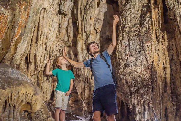 Papá e hijo turistas en Hang Sung Sot Grotto Cave of Surprises, Halong Bay, Vietnam. Viajar con concepto de niños. Turismo después del coronavirus — Foto de Stock