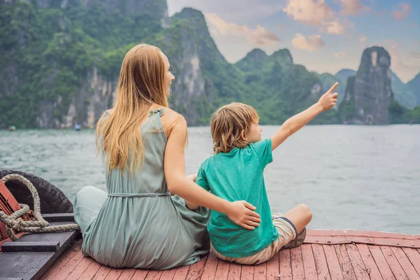 母と息子の旅行者はハロン湾でボートで旅行しています。ベトナム。アジアへの旅行、幸福感、夏休みのコンセプト。子供の概念で旅行。COVIDの後19.絵のように美しい海の風景 — ストック写真