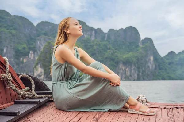 Elbiseli çekici bir kadın Halong Körfezi 'nde tekneyle seyahat ediyor. Vietnam. Asya 'ya seyahat, mutluluk duygusu, yaz tatili konsepti. Resimli deniz manzarası. Ha Long Körfezi, Vietnam — Stok fotoğraf