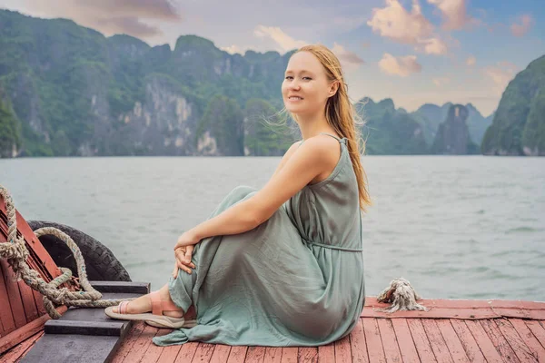 Attraktive Frau im Kleid ist mit dem Boot in der Halong-Bucht unterwegs. Vietnam. Reise nach Asien, Glücksgefühle, Sommerurlaubskonzept. Malerische Meereslandschaft. Ha Long Bay, Vietnam — Stockfoto