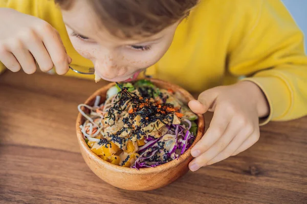 Хлопчик їсть сиру органічну миску з рисом і Веджі крупним планом на столі. Вид зверху горизонтально — стокове фото