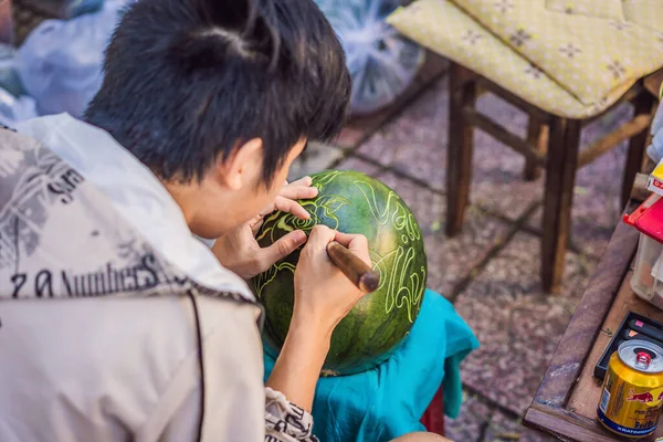 2013 년 1 월 23 일에 확인 함 . Vietnam, Nha Trang, January 23, 2020: Asian man working on pavement of farmers market, Vietnam male engraving on watermelon to ornaming on Tet — 스톡 사진