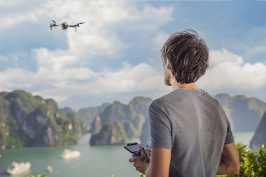 Halong Körfezi 'nde insansız hava aracını kontrol eden adam. Vietnam. Asya 'ya seyahat, mutluluk duygusu, yaz tatili konsepti. Resimli deniz manzarası. Ha Long Körfezi, Vietnam