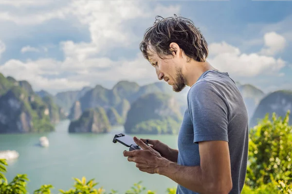 Egy ember irányít egy drónt a Halong-öbölben. Vietnámban. Utazás Ázsiába, boldogság érzelem, nyaralás koncepció. Festői tengeri táj. Ha Long Bay, Vietnam — Stock Fotó