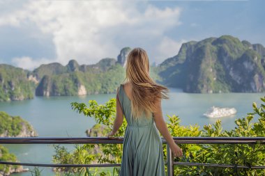 Elbiseli çekici bir kadın Halong Körfezi 'nde seyahat ediyor. Vietnam. Asya 'ya seyahat, mutluluk duygusu, yaz tatili konsepti. Resimli deniz manzarası. Ha Long Körfezi, Vietnam