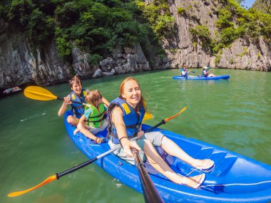 Mom, dad and son travelers rowing on a kayak in Halong Bay. Vietnam. Travel to Asia, happiness emotion, summer holiday concept. Traveling with children concept. After COVID 19. Picturesque sea clipart