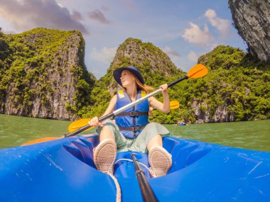Anne, baba ve oğul Halong Körfezi 'nde kano üzerinde kürek çekiyorlar. Vietnam. Asya 'ya seyahat, mutluluk duygusu, yaz tatili konsepti. Çocuk konseptiyle seyahat etmek. Ölüm nedeni 19 'dan sonra. Resimli deniz.