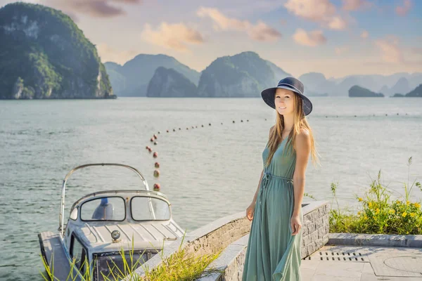 Attractive woman in a dress is traveling in Halong Bay. Vietnam. Travel to Asia, happiness emotion, summer holiday concept. Picturesque sea landscape. Ha Long Bay, Vietnam