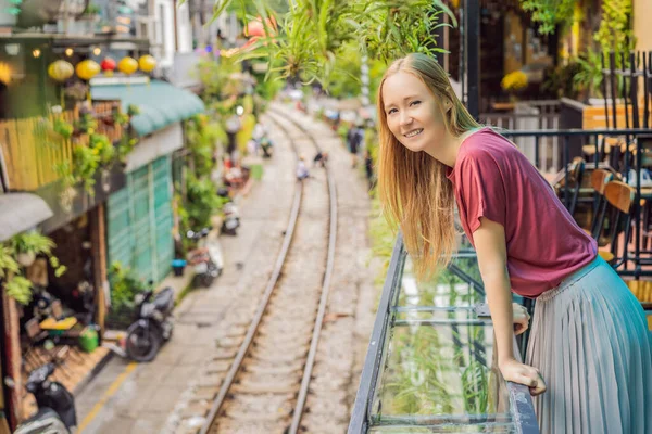 Frau läuft auf der Stadtbahn von Hanoi. Perspektivischer Blick, der entlang einer engen Straße mit Häusern in Vietnam verläuft. Hanoi Eisenbahnstraße, altes Haus und Eisenbahn. Vietnam öffnet nach Coronavirus-Quarantäne wieder — Stockfoto