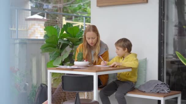 Egy fiatal nő és a fia egy gyönyörű kávézóban vacsoráznak, ahol bögrés tálakat szolgálnak fel. Kiválasztják a hozzávalókat. — Stock videók