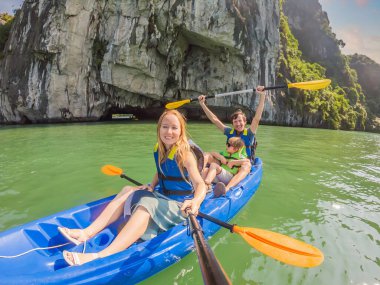 Anne, baba ve oğul Halong Körfezi 'nde kano üzerinde kürek çekiyorlar. Vietnam. Asya 'ya seyahat, mutluluk duygusu, yaz tatili konsepti. Çocuk konseptiyle seyahat etmek. Ölüm nedeni 19 'dan sonra. Resimli deniz.