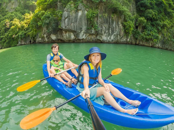 Mamma, papà e figlio viaggiatori a remi su un kayak a Halong Bay. Vietnam. Viaggio in Asia, emozione felicità, concetto di vacanza estiva. Viaggiare con il concetto di bambini. Dopo il COVID 19. Mare pittoresco — Foto Stock