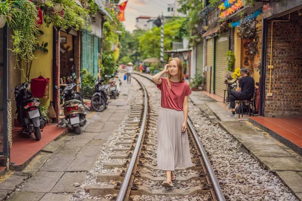 Mulher está caminhando de ferrovia cidade de Hanói. Vista prospectiva correndo ao longo da rua estreita com casas no Vietnã. Rua de trem Hanói, casa velha e ferrovia. Vietname reabre após quarentena com coronavírus — Fotografia de Stock