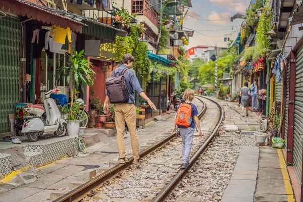 Apa és fia utazók sétálnak a vasúti ösvények, amelyek átmennek lakóövezetben Hanoi városban. Hanoi Train Street egy híres turisztikai célpont. Vietnam újra megnyílik a koronavírus karantén után — Stock Fotó