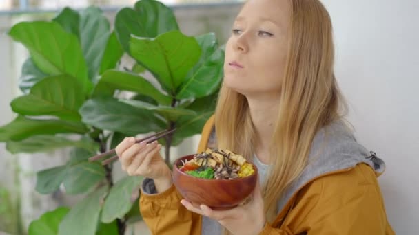 Genç bir kadın, yemek kaselerinin servis edildiği güzel bir kafede yemeğin tadını çıkarıyor. Hızlı ve sağlıklı. Moda gıda konsepti — Stok video