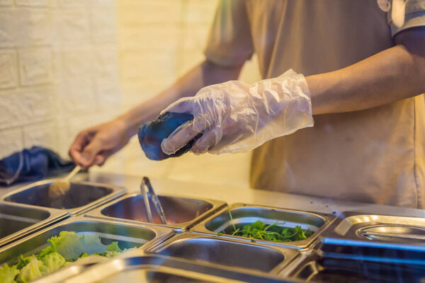 The man is cooking Vietnamese Pork Banh Mi Sandwich in a black baguette.