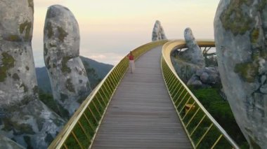 Danang şehrindeki Altın Köprü 'de yürüyen genç bir kadının yavaş çekim görüntüsü. Vietnam 'ın merkezinde bir turizm merkezi. Vietnam 'a seyahat